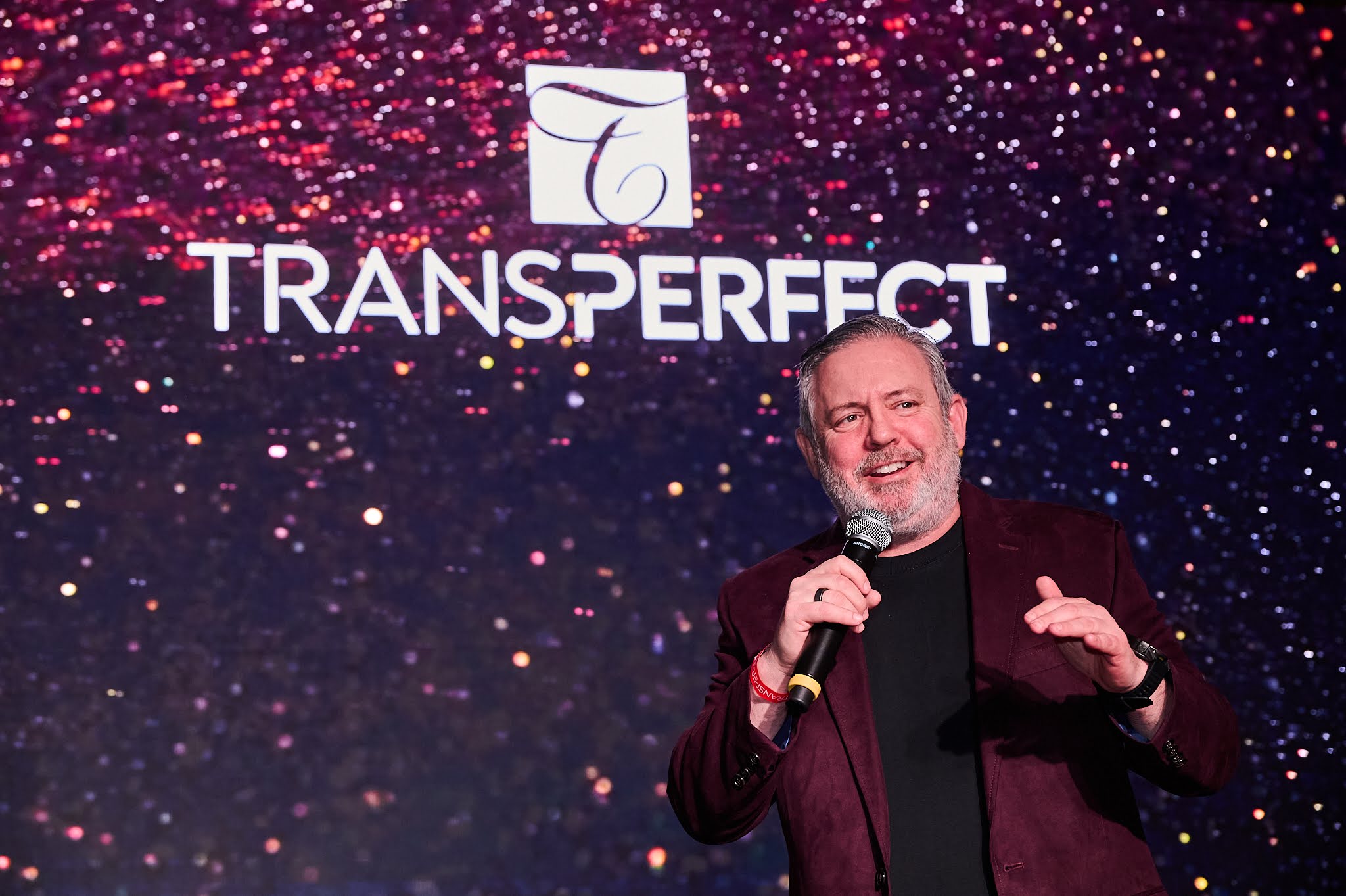 Phil Shawe in front of the TransPerfect logo
